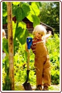 Helping children love nature - Small boy helping in garden